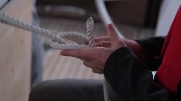 女性タイ複雑な結び目のロープ作業上のヨット — ストック動画