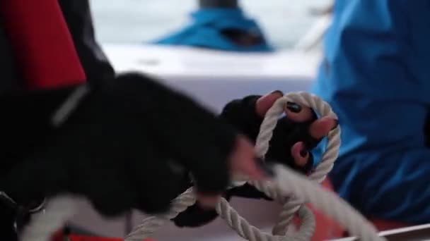 Леди связывает матрос узел веревки на яхте с друзьями — стоковое видео