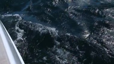 Derin mavi deniz dalgaları soğuk güneşli bir günde yelkenli yattan akıyor.