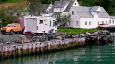 Babası küçük oğluna limanda oltayla balık tutmayı öğretiyor.