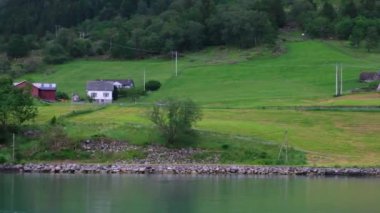 Otomobil, deniz kıyısındaki köy boyunca yol boyunca gidiyor.