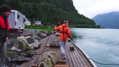 Denizciler limandaki yatın korkuluklarına şamandıra asarlar.