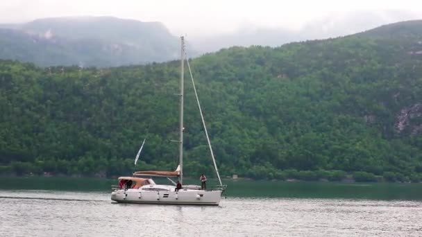 Deportistas a pie en la cubierta de yate navegando más allá de la colina verde — Vídeo de stock