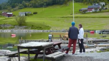 Bir adam ve bir kadın Sundal Norveç 'teki rıhtımda duruyor.