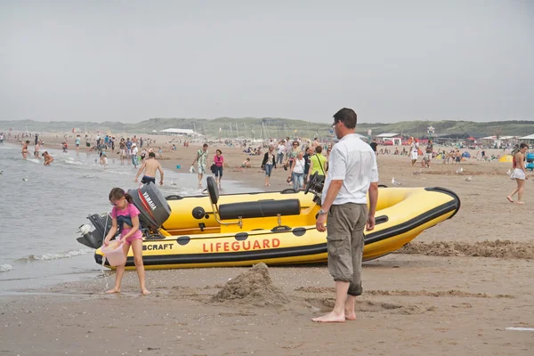 Denhaag, Niederlande: 21. august 2011 - mann mit kindern am strand in scheveninge — Stockfoto