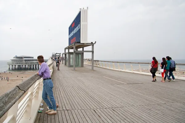 Denhaag, Holandia: 21 sierpnia, 2011 - molo w scheveningen i kobieta gościem — Zdjęcie stockowe