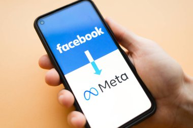 Nizhny Novgorod, Rusya, 30 Ekim 2021: Facebook adını meta olarak değiştirdi. turuncu arka planda el ile yeniden adlandırma kavramına sahip akıllı telefon ekranı.