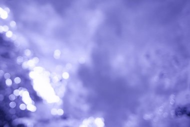 Su transfüzyonu ve bulanık arka plan ışığı. 2022 yılının rengi - Çok Peri. Bokeh ile asgari eflatun mor soyut arkaplan