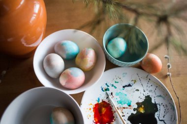 Tabaklara boyanmış yumurtalar. Paskalya için hazırlanıyorum. suluboya etkisi için boya ve fırça kullanılıyor.