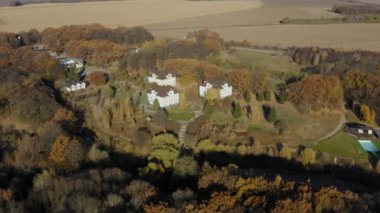 Bir kuşun gözünden güzel bir sonbahar ormanı. Yüksekten insansız hava aracından ateş etmek. Güneşte karışık bir orman. Turuncu, yeşil ve kırmızı boyalar. Yaprak döken ve kozalaklı ağaçlar.