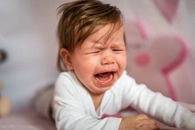 Küçük beyaz bir kız. Beş aylık. Karnının üstüne yatmış, gün içinde ağlıyor.