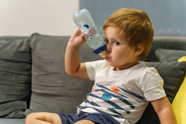 Small Caucasian Boy Holding Baby Bottle While Sitting Bed Home — Stock Photo, Image