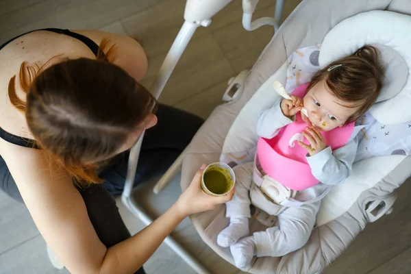 Fütterung Kleiner Kaukasischer Babys Mit Silikon Lätzchen Mit Brokkoli Gemüsepüree — Stockfoto