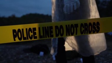 Adli polis müfettişi gece vakti nehrin kıyısındaki suç mahallinde kanıt topluyor. Seçici bir şekilde polis hattına odaklanıyor. Ağır çekimde cinayet çözerken bant kullanmayın.