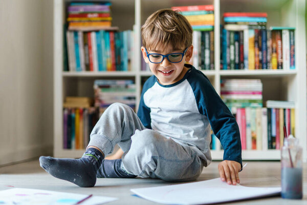 Front view on four years old caucasian boy playing on the floor at home