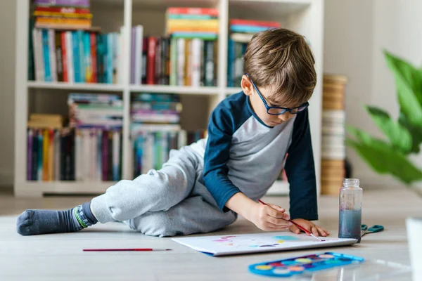 4歳の白人男の子の家で床で遊ぶフロントビュー 小さな子供は絵筆を使用しながら水彩画を描くコンセプトレジャーや創造的な教育を成長させる芸術スキルを開発 — ストック写真