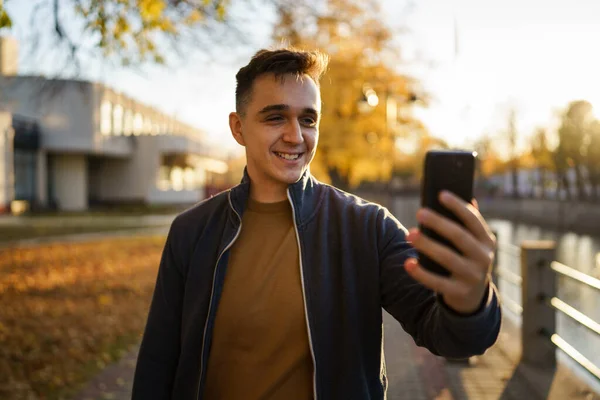 Młody Kaukaski Mężczyzna Stojąc Samotnie Zewnątrz Jesienny Wieczór Telefon Wideo — Zdjęcie stockowe