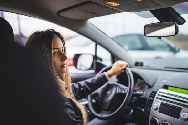 若いです大人1つのCaucasian女性運転車待っていますながらホイールを保持しながらサイドバックビュー女性ドライバーコピースペースリアル人々 — ストック写真