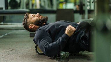 Spor adamı Kas ve Fasya için siyah köpük tekerlekli paten kullanıyor - Erkek sporcu spor salonundaki antrenmandan sonra ağrılı kasları rahatlatıyor - sağlık ve spor vücut bakımı konsepti
