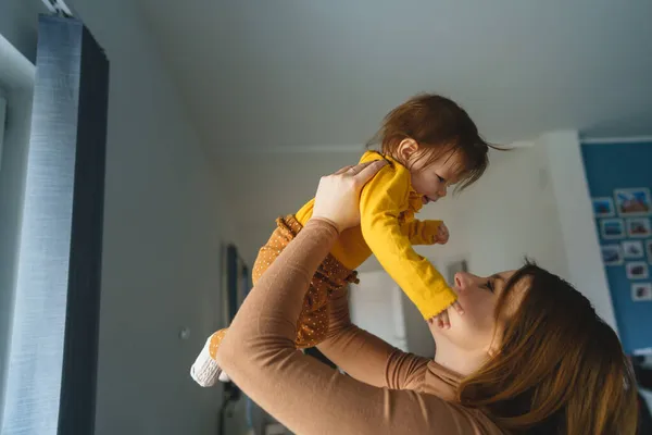 Una Pequeña Niña Caucásica Feliz Las Manos Madre Sosteniéndola Casa — Foto de Stock