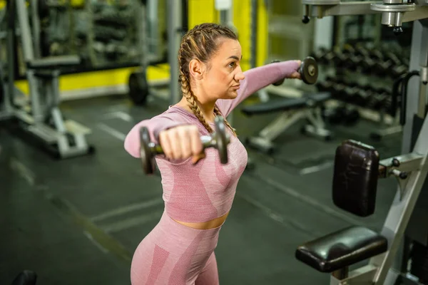 一名成年高加索女子在健身房练举重哑铃肩膀训练女运动员的蜡像真人健康健身理念 — 图库照片