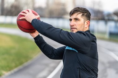 Stadyumdaki yetişkin beyaz erkek atlet eğitiminin bel hizasında - bahar ya da sonbahar günlerinde tıp topu kullanan adam - fotokopi alanı ile portreyi kapatın