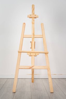 Beyaz duvarın önünde ahşap sehpa var.