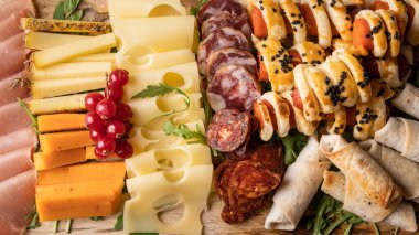 Masadaki aperatifleri kapatın. Peynir ve sosisler tam kare.