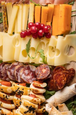 Masadaki aperatifleri kapatın. Peynir ve sosisler tam kare.