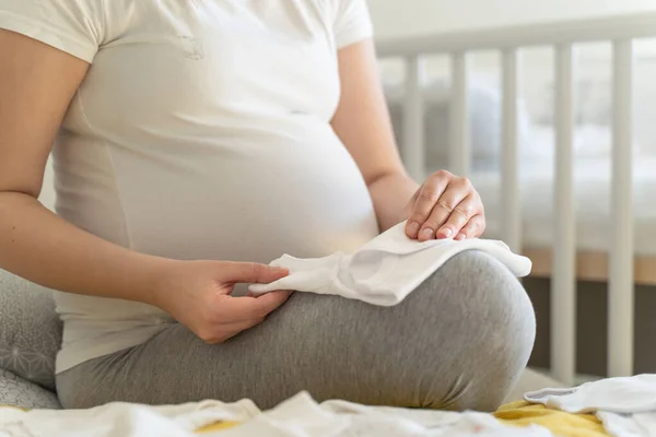 Middensectie Van Onbekende Blanke Vrouw Zitten Bed Houden Babykleertjes Door — Stockfoto