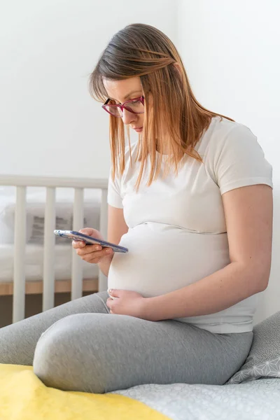 Zwangere Blanke Vrouw Met Behulp Van Mobiele Telefoon Tijdens Het — Stockfoto