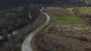 Otomobil Aerial görüntüsü yukarıdan aşağıya, dağ sırasındaki dağ yolunda, etraftaki çimenler ve ağaçlar arasında takip ediliyor- Sırbistan 'daki Stara Planina Eski Dağı' nda doğa yolculuğu konsepti dronu