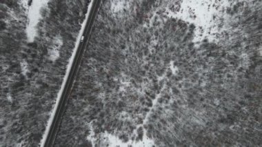 Seyahat yolculuğu ve tatil konsepti Sırbistan 'ın Knjazevac kenti yakınlarında kış günü beyaz karla dağlık alanda giden kıvrımlı serpentin yol aracının yüksek açılı hava aracı videosu