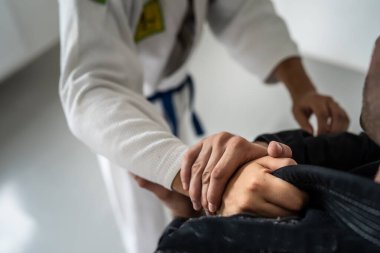 Brezilyalı Jiu Jitsu BJJ eğitim sırasında ya da dövüş sanatları konseptini uygularken ellerinizi yakın tutun ve kimonoyu sıkıca tutun.