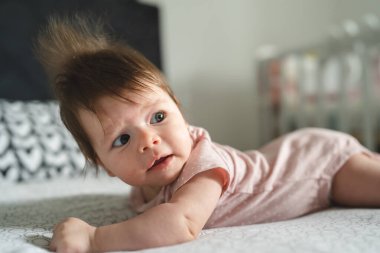Küçük, beyaz bir bebek. Dört aylık. Evdeki parlak odada yatıp fotokopi çektiriyor.