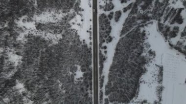 Seyahat yolculuğu ve tatil konsepti. Sırbistan 'ın Knjazevac kenti yakınlarında kış günü beyaz karla dağlık alanda giden otomobil üzerindeki yüksek açılı hava aracı videosu.