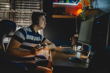 Kafkasyalı genç bir erkek bilgisayarında video oyunları oynuyor. Karanlıkta, kafasında kulaklıklarla tek başına monitöre bakıyor. Gerçek insanlar uzayı kopyalıyor.