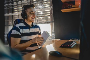 İnternet dersi sırasında bilgisayar başında karanlık bir odada oturup rehber ya da özel öğretmen olarak internetten eğitim alan beyaz bir genç adam gerçek insanlar.