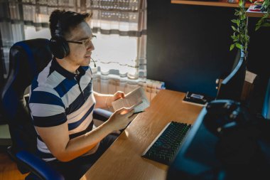 İnternet dersi sırasında bilgisayar başında karanlık bir odada oturup rehber ya da özel öğretmen olarak internetten eğitim alan beyaz bir genç adam gerçek insanlar.