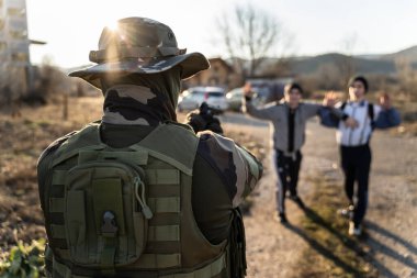 Güneşli bir günde sınır devriyesinde görevli askerler tarafından tutulan iki göçmen grubu, iki meçhul adam, yasadışı faaliyetten tutuklandıktan sonra yolda silahlı adamla karşı karşıya geldi.