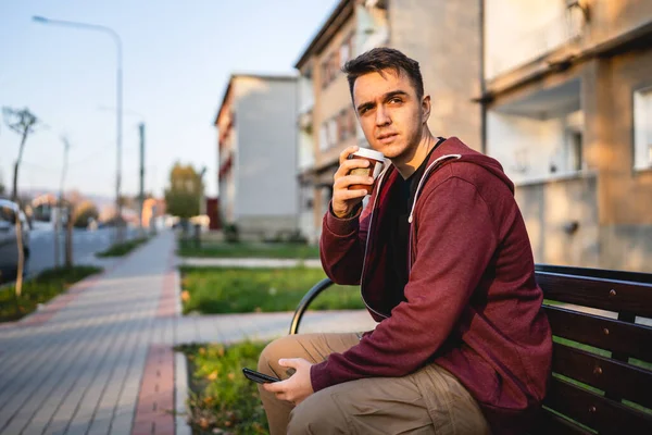 Jeden Mladý Dospělý Běloch Sedí Venku Lavičce Podzimním Dni Mobilním — Stock fotografie