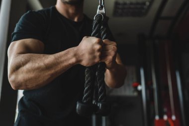 Kas egzersizi için halat kullanan beyaz adamın ellerini kapatın. Kas geliştirici trisepsler, fotokopi uzayı karanlık fotoğraf eğitimi veriyor.