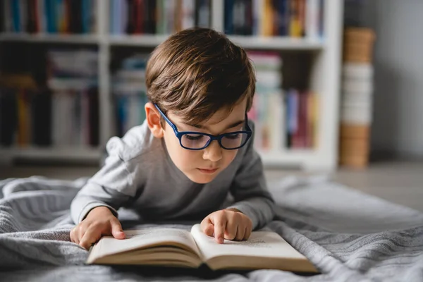 一人の白人少年が家の床に横になって本を読んでフロントビューコピースペース現実の人々の教育の概念 — ストック写真