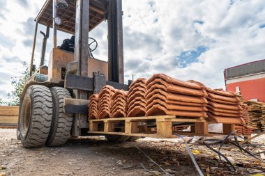 Depo çatal kaldırıcısı için forklift yükleyicisi çalışmaya hazır inşaat malzemesi çatı kiremitleri taşı