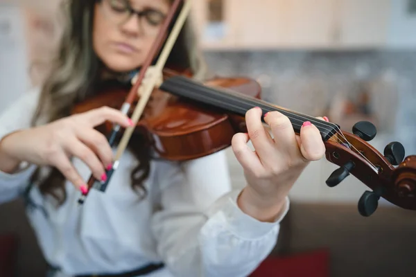 家庭で音楽を演奏し コンセプトを練習するために家庭学習でバイオリンを保持大人の白人女性のフロントビューの肖像画実際の人々は 楽器や手に選択的な焦点をコピーします — ストック写真