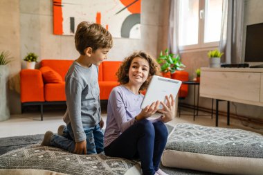 Kardeşler, kız ve erkek kardeşler, kız ve erkek kardeşler, ya da evde dijital tablet kullanan çocuklar. Video izlemek, arama yapmak ya da oyun oynamak için.