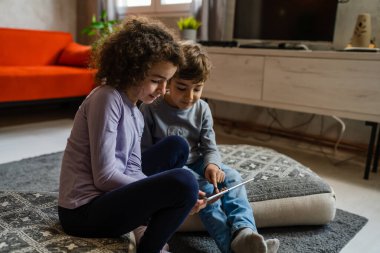 Kardeşler, kız ve erkek kardeşler, kız ve erkek kardeşler, ya da evde dijital tablet kullanan çocuklar. Video izlemek, arama yapmak ya da oyun oynamak için.