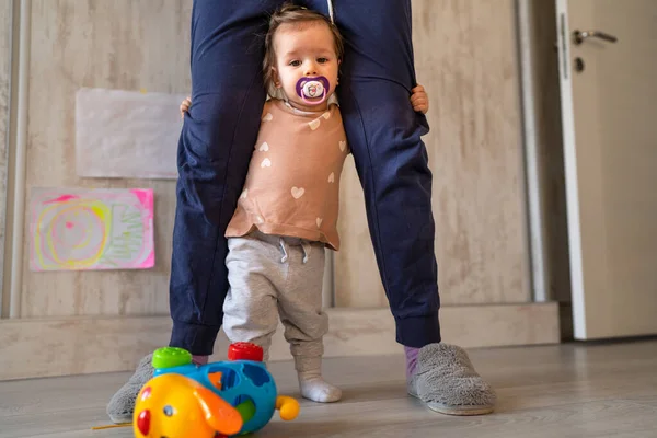 一个小小的高加索女婴站在她不认识的母亲的两腿中间 抱着她寻求支持 全景全景实景真人复制空间 — 图库照片