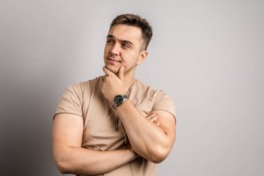 25 yaşında beyaz saçlı yetişkin bir adamın portresi. Beyaz duvarın önüne bakıyor. Tişört fotokopi alanı giydiğini düşünüyor.