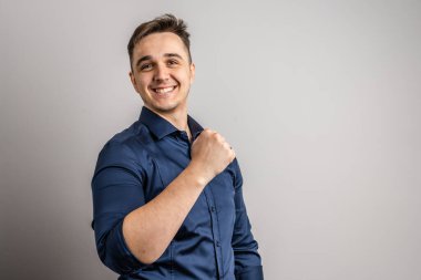 Kafkasyalı mutlu bir erkek stüdyonun ön görüntüsünü çekti başarıyı kutladı, olumlu duygular ve jest gülümsemesi güçlü bir şekilde kameranın kaslarına baktı.